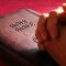 pexels-photo-267559-267559 Close-up of hands praying on a Holy Bible, symbolizing faith and spirituality.